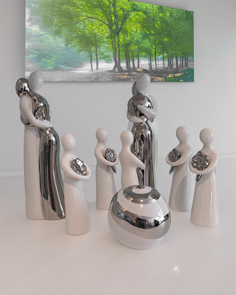 menschliche trauernde Figuren stehen im Kreis, einige umarmen einander