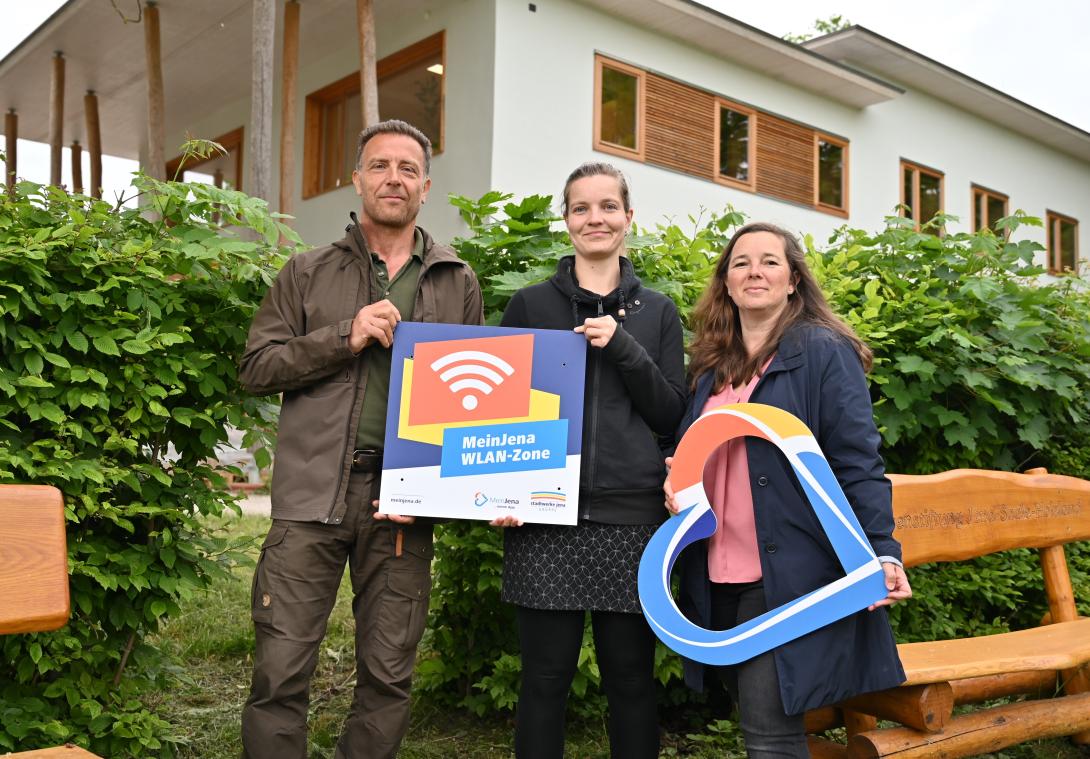 Stadtförster Olaf Schubert, Franziska Vogelsang vom Stadtforst und Christina Hentschel von den Stadtwerken (v.l.) freuen sich, dass das Mein Jena-WLAN nun auch im Bereich des Naturerlebniszentrums am Schottplatz ausgestrahlt wird