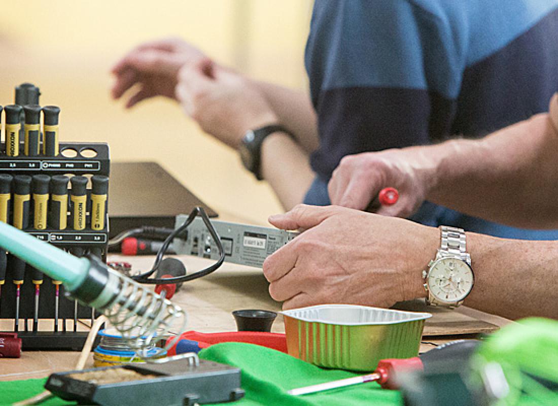 Hände reparieren ein elektronisches Gerät